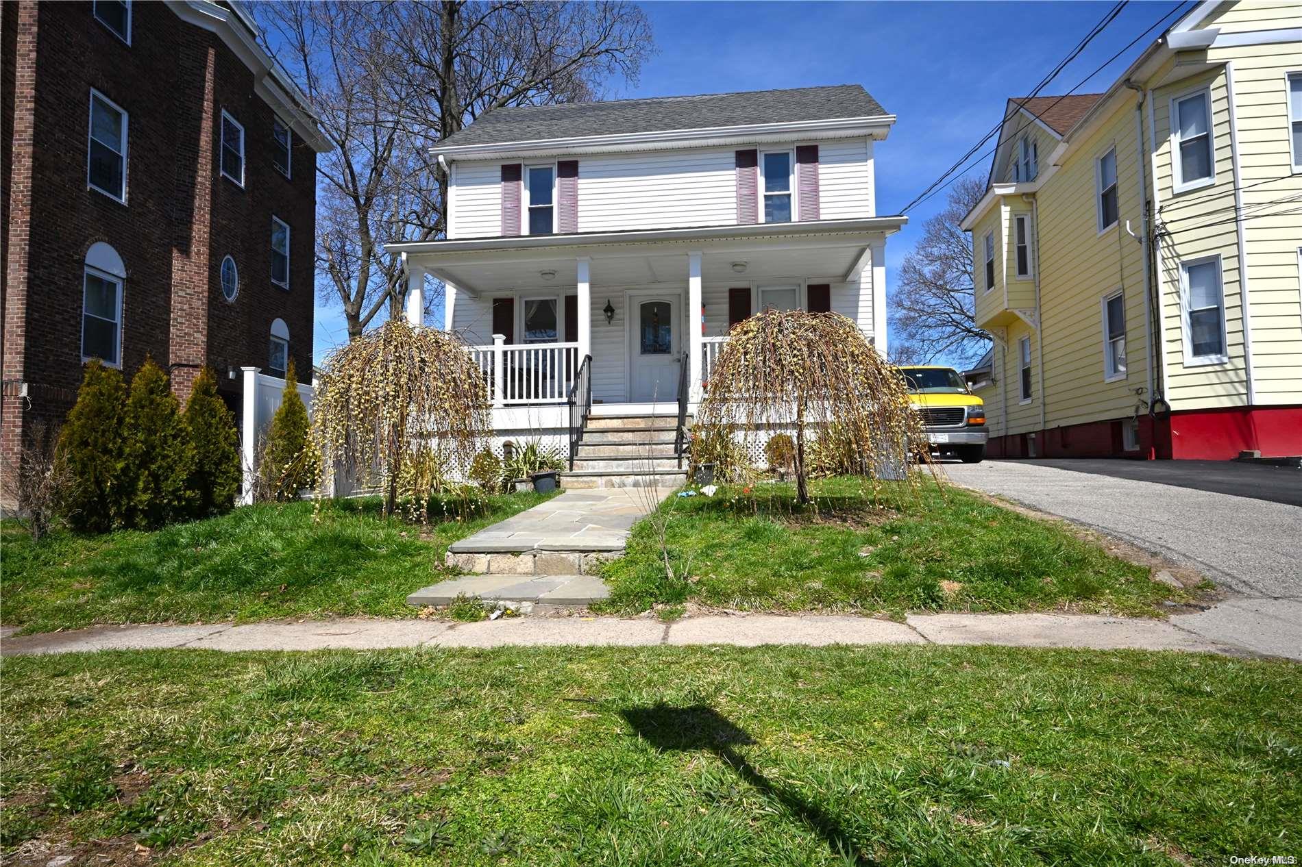 a front view of a house with garden and porch