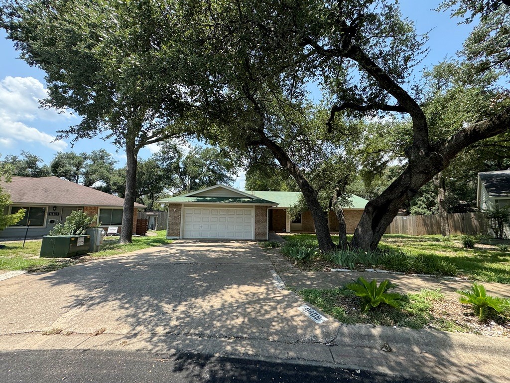 a front view of a house with a yard and trees