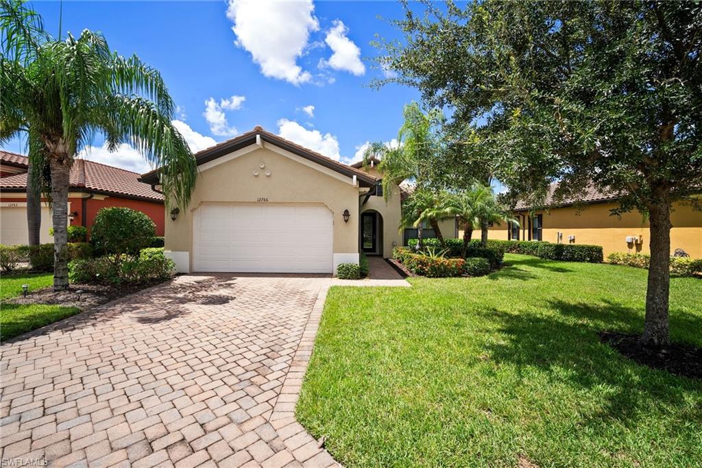 Mediterranean / spanish-style house featuring a garage and a front lawn