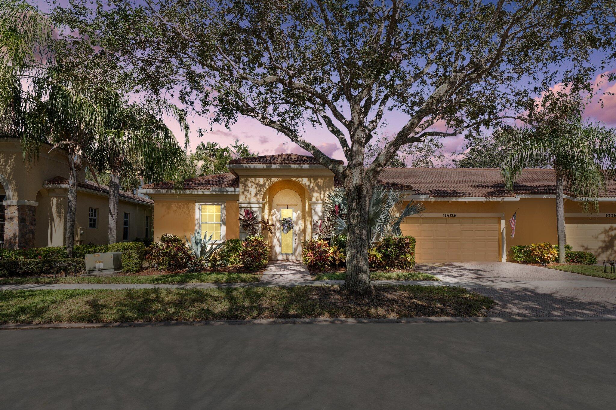 a front view of a house with a yard and tree s