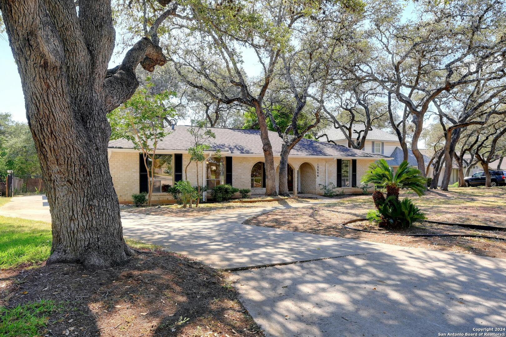 a front view of a house with a yard and potted plants