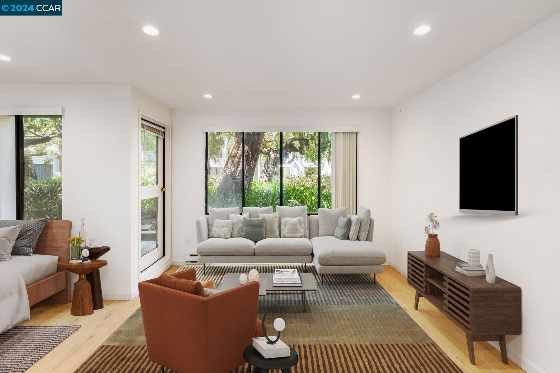 a living room with furniture a flat screen tv and a large window