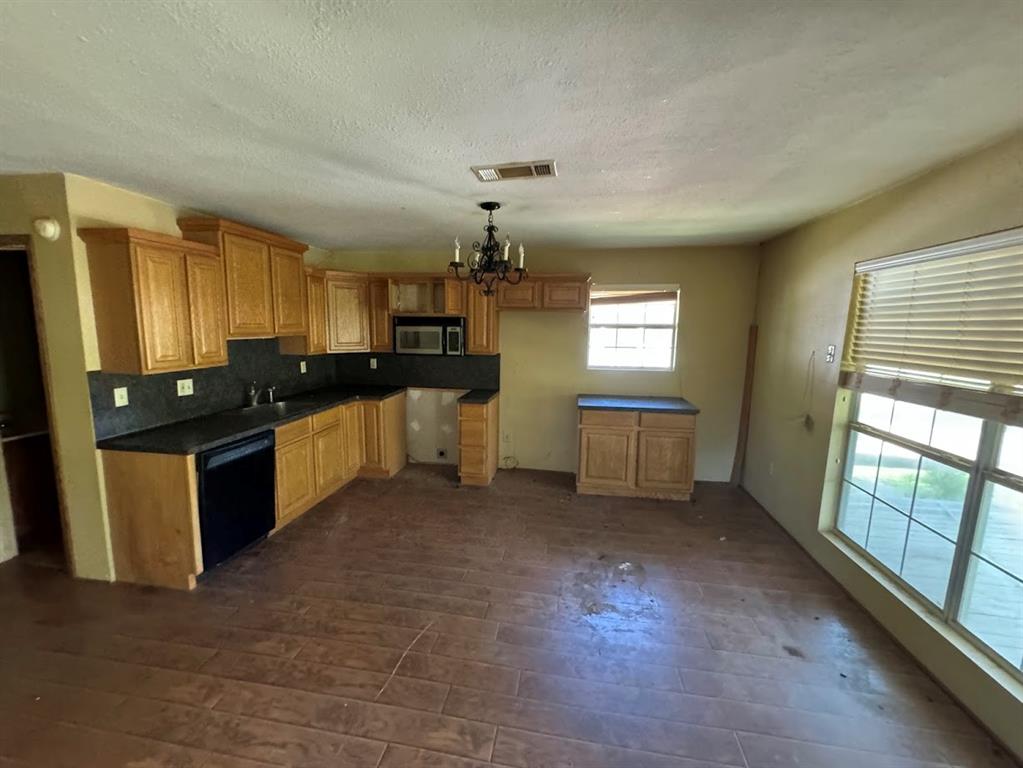 a kitchen with granite countertop a stove a sink dishwasher and a refrigerator