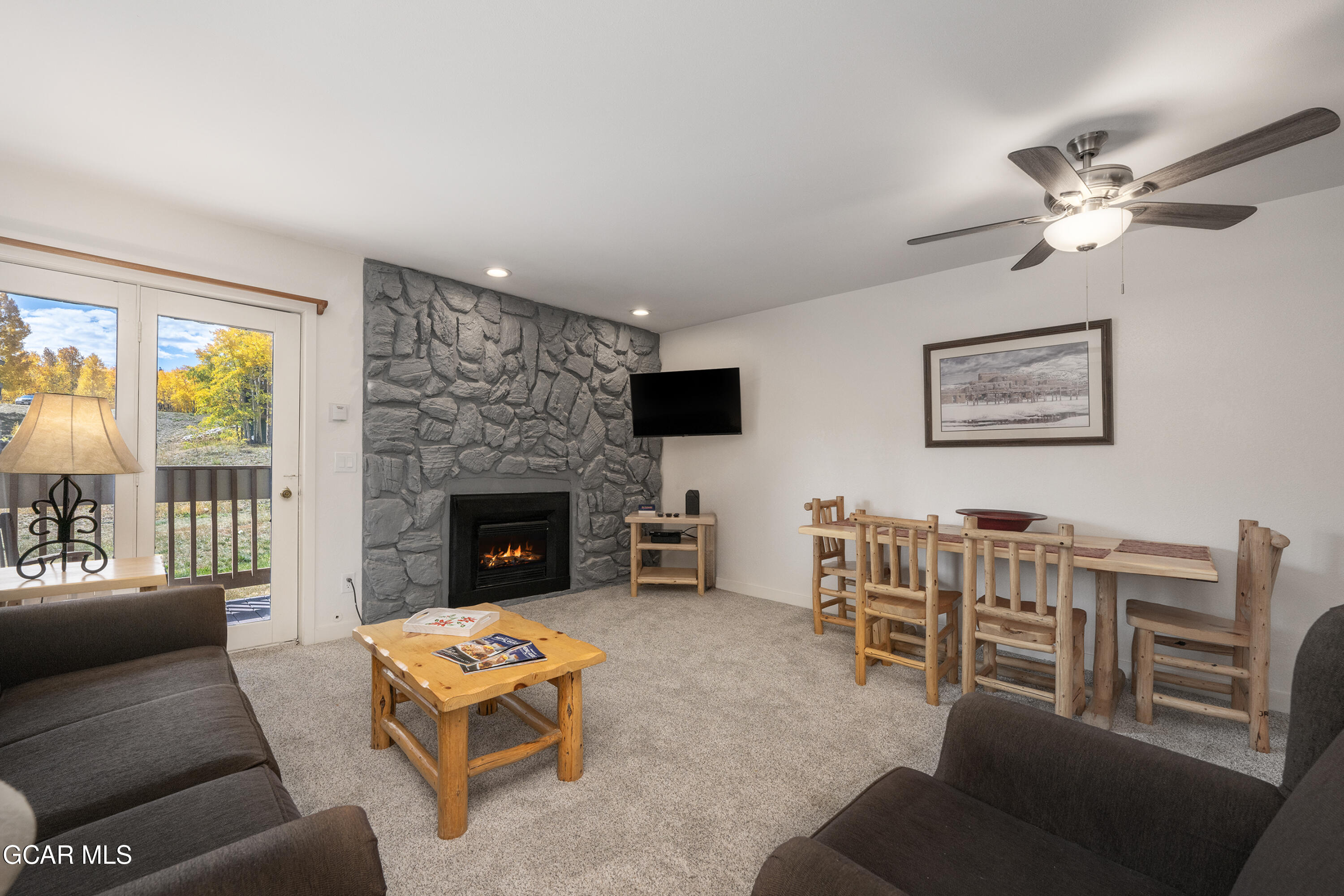 a living room with furniture a flat screen tv and a fireplace