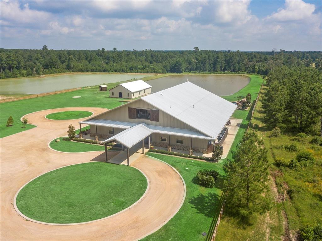 an aerial view of a house with a garden and lake view