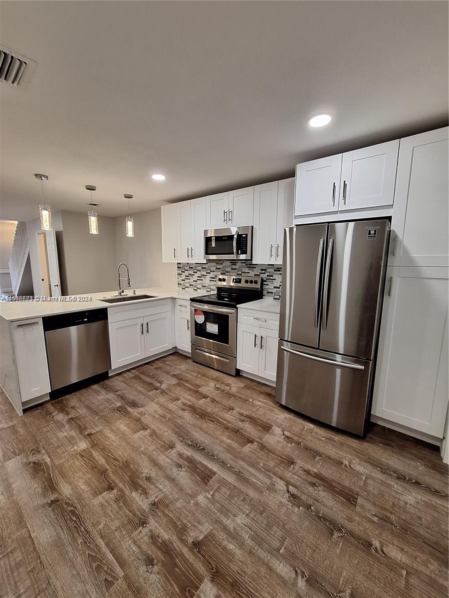 a kitchen with stainless steel appliances granite countertop a refrigerator sink and stove