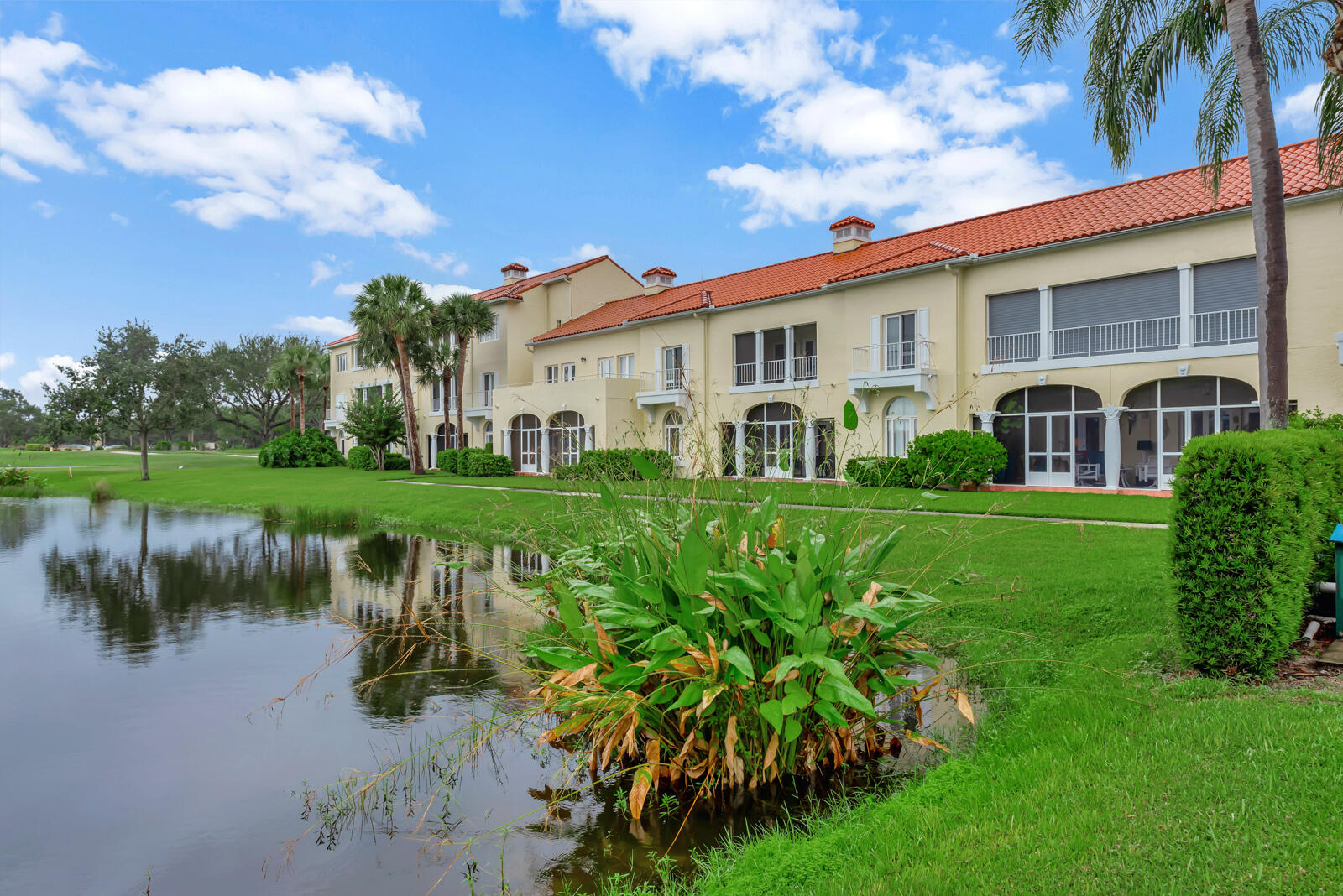 a front view of a house with a garden and lake view