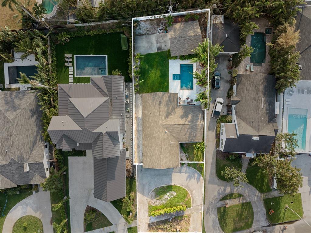 an aerial view of a house with a yard potted plants and large tree