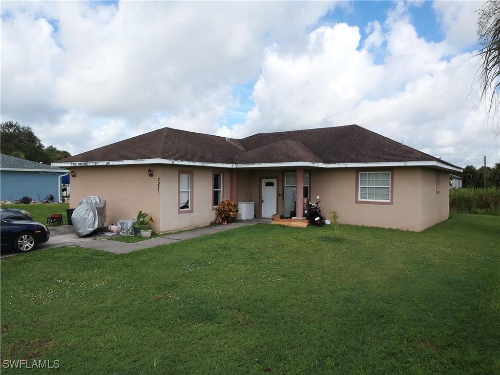 a view of a house with a yard and sitting area