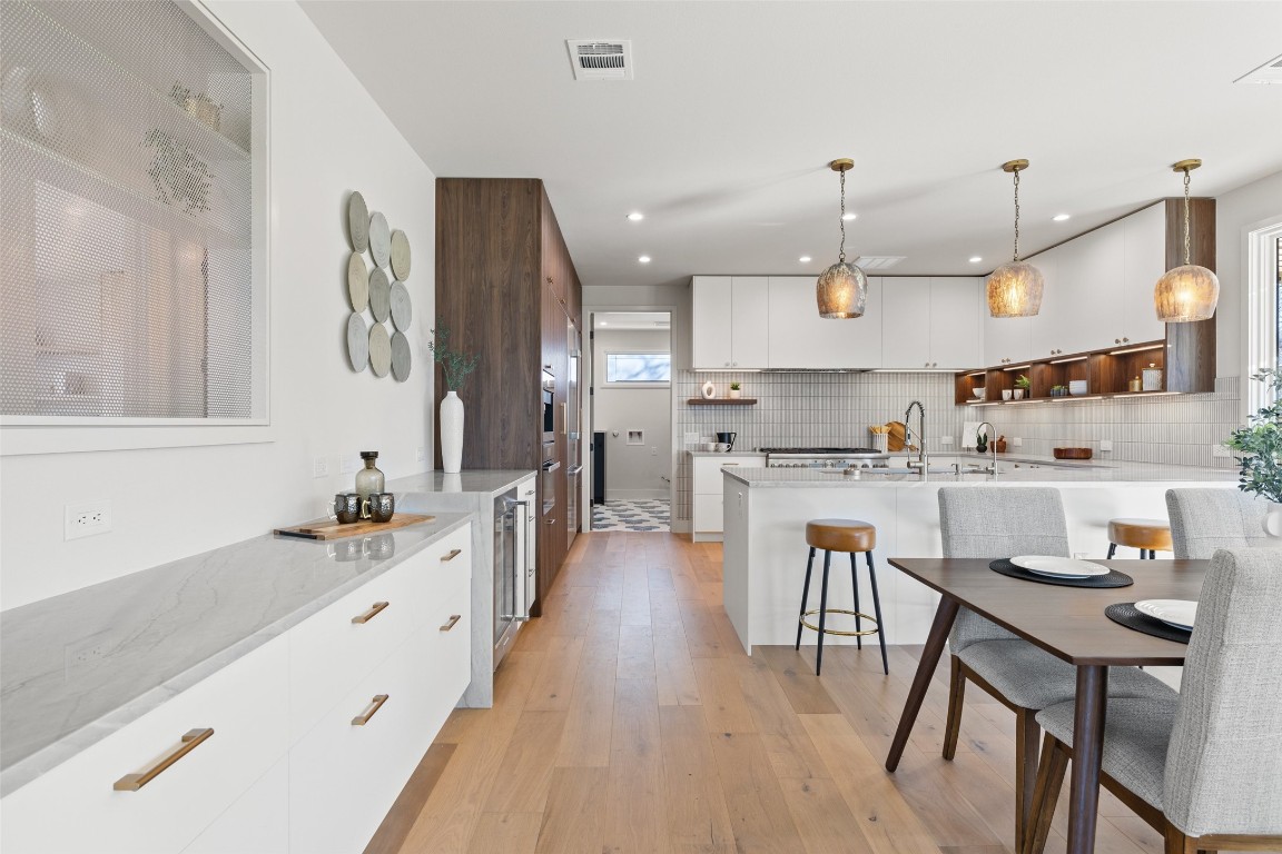 a kitchen with kitchen island granite countertop a sink cabinets and wooden floor