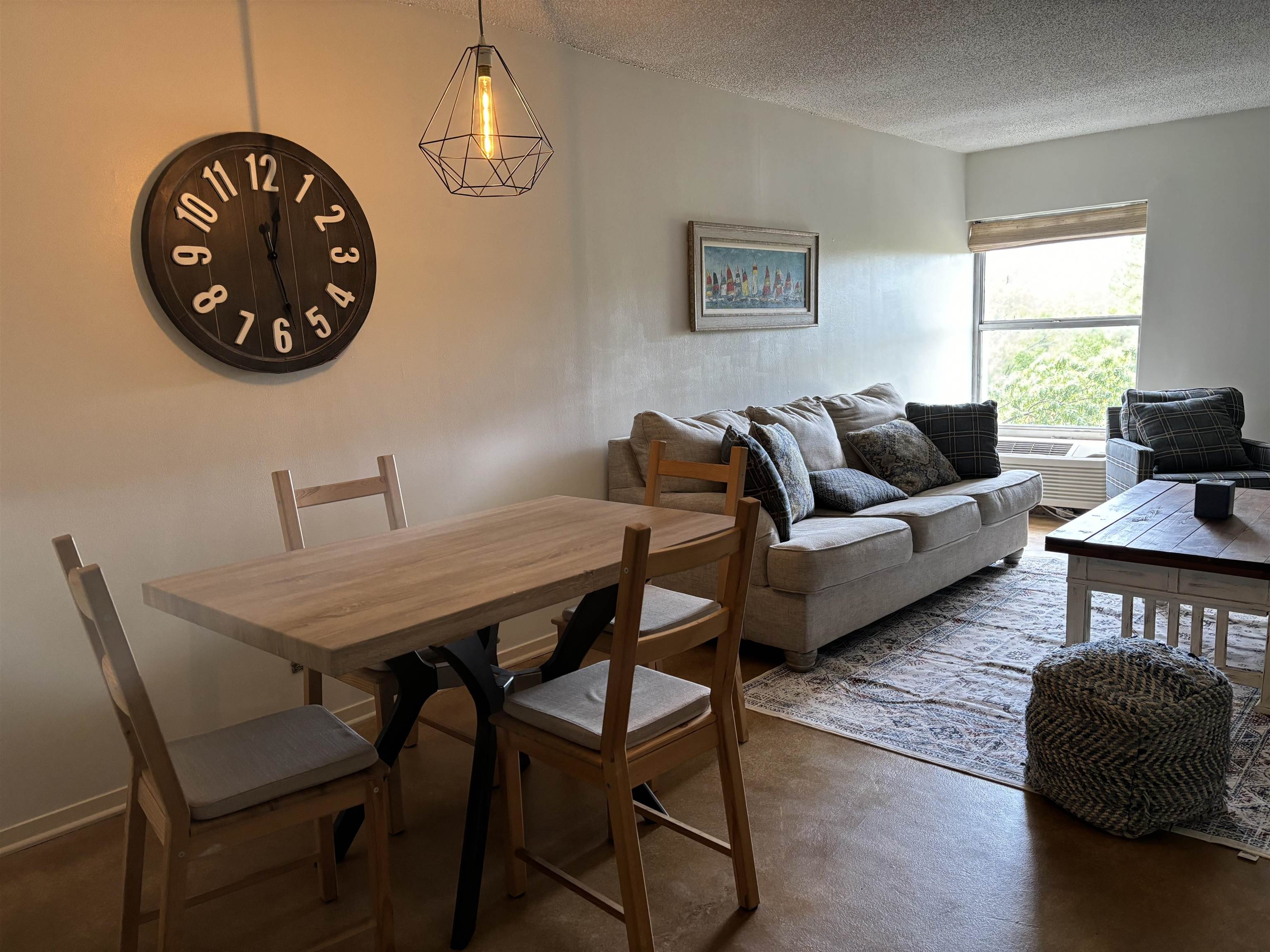 a living room with furniture a rug and a window