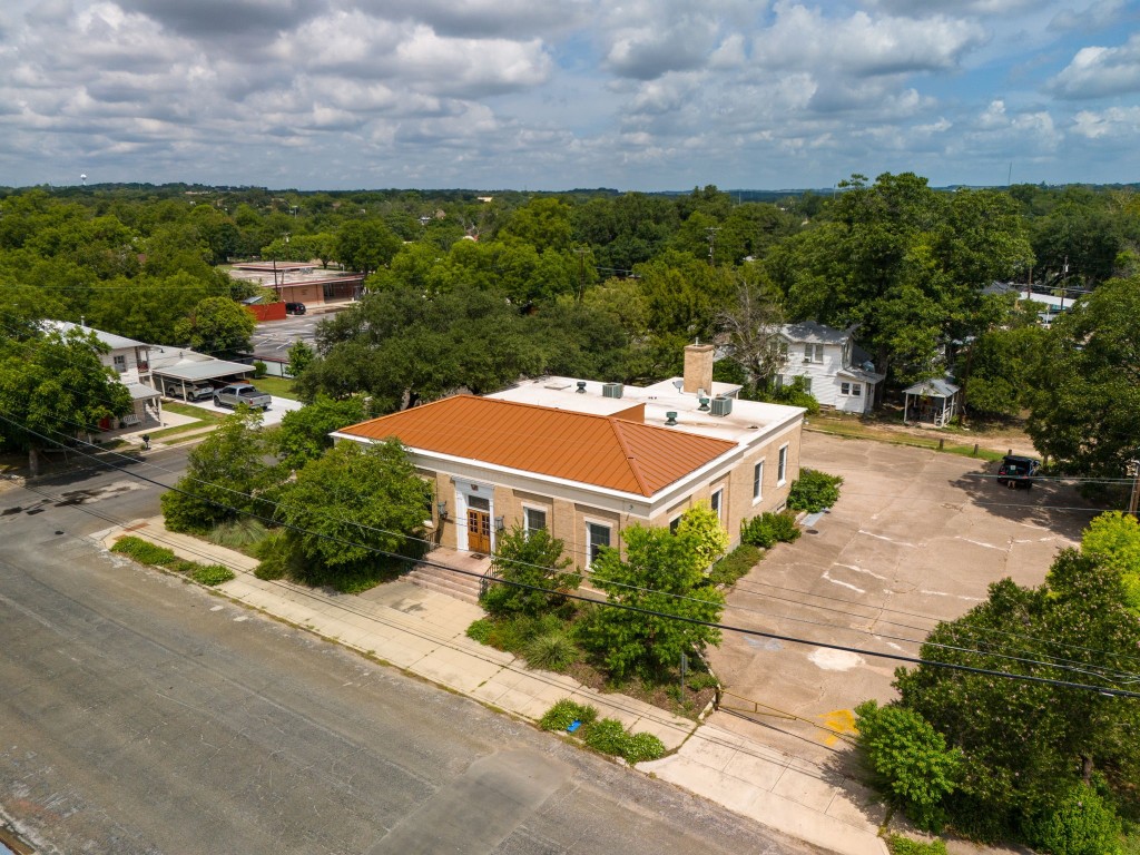 an aerial view of a house with yard and green space