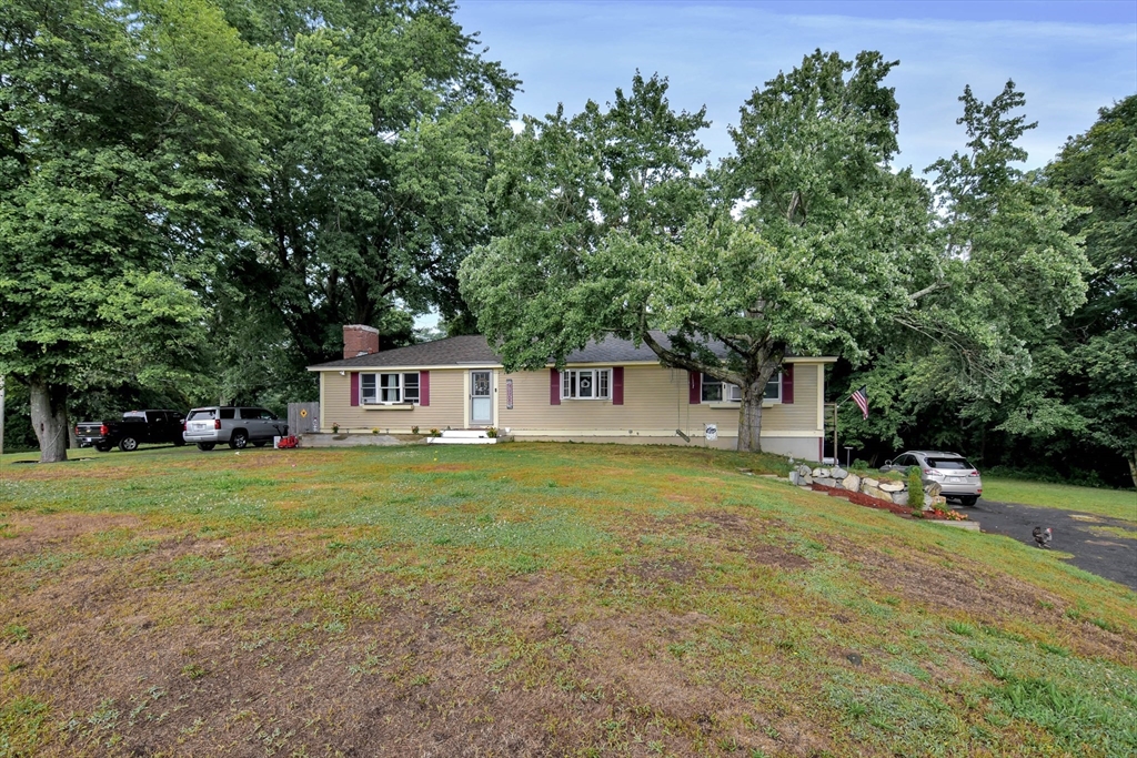 a view of a house with a yard and sitting area