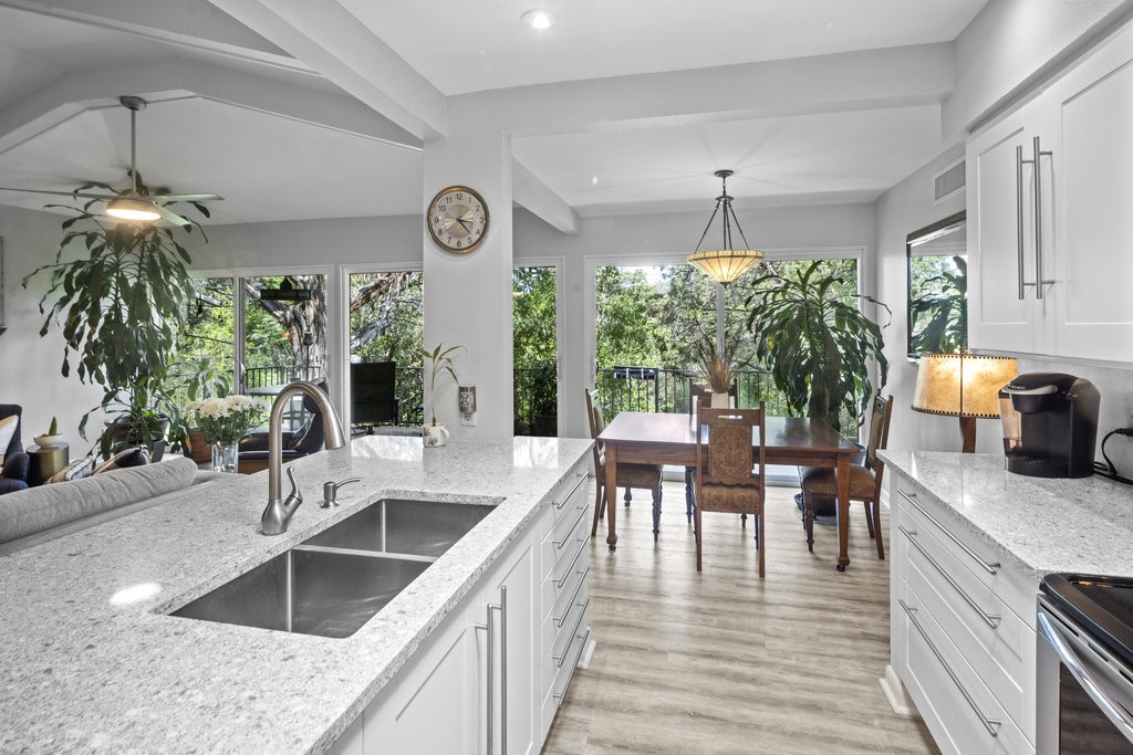 a kitchen with granite countertop a sink and stove top oven