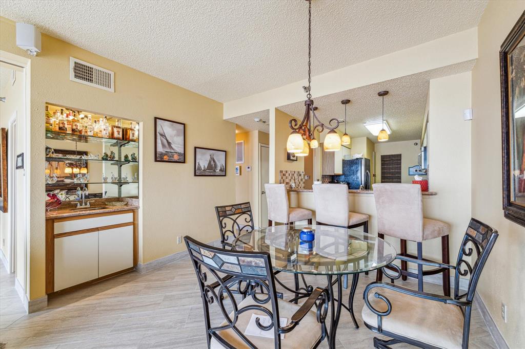 Dining area with a beautiful wet bar.  Brand new tile throughout condo except primary bedroom which has brand new, plush carpet.