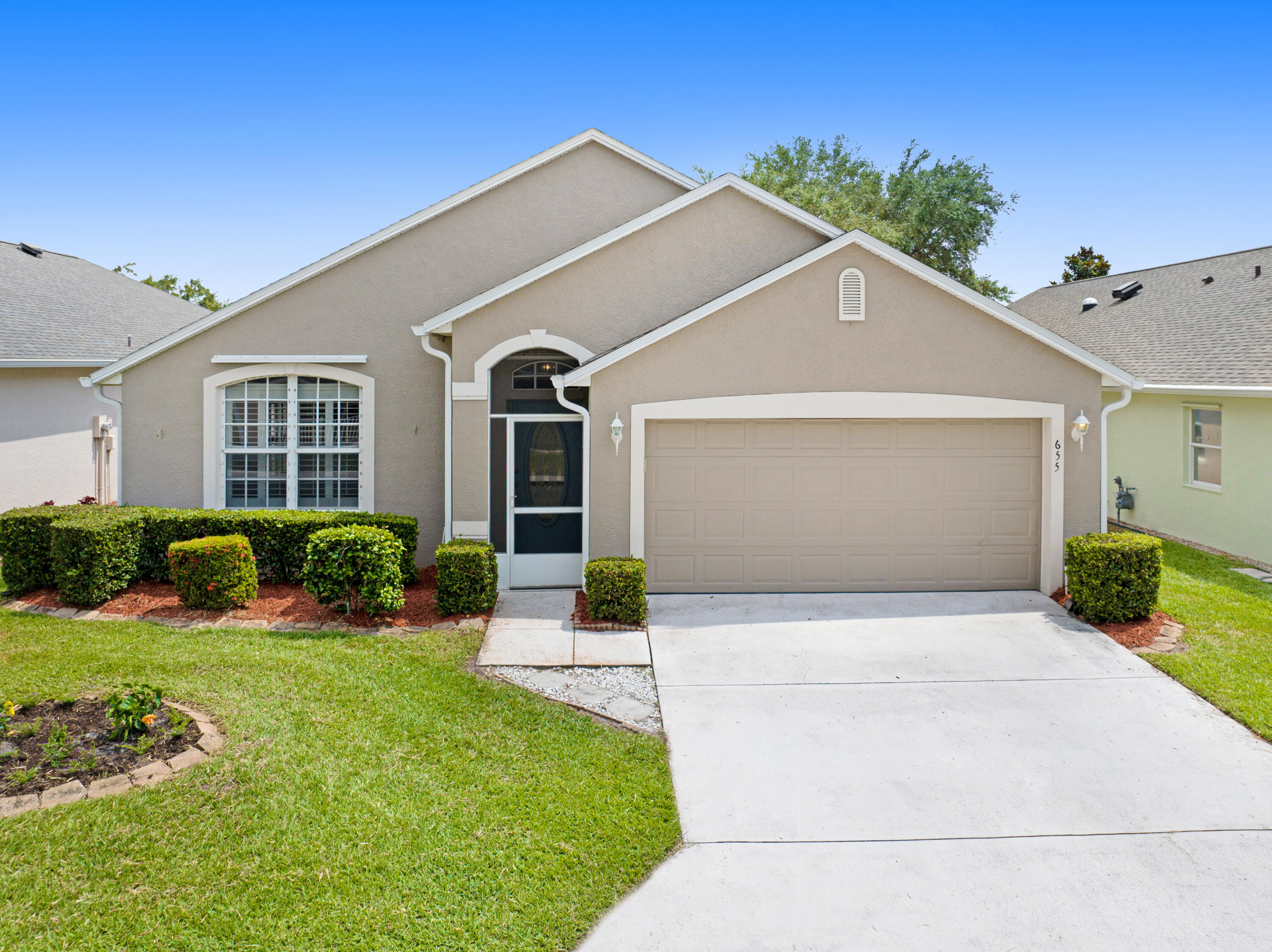 a front view of a house with yard and green space