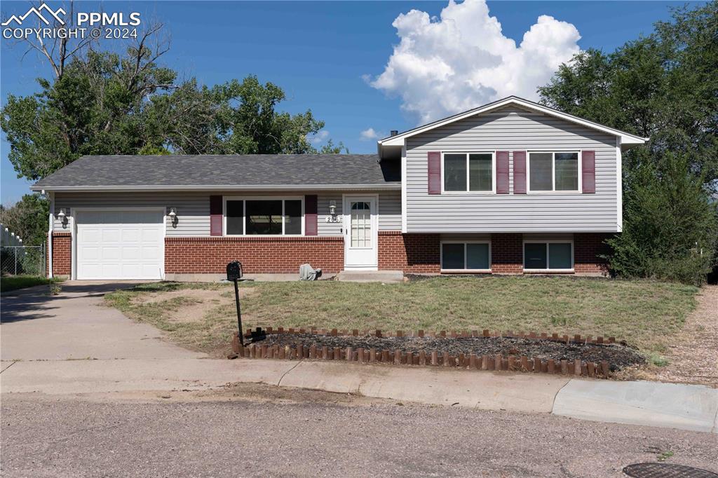 4-level home with a garage and a front lawn