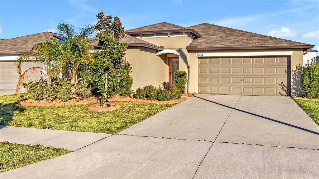 a front view of a house with a yard and garage