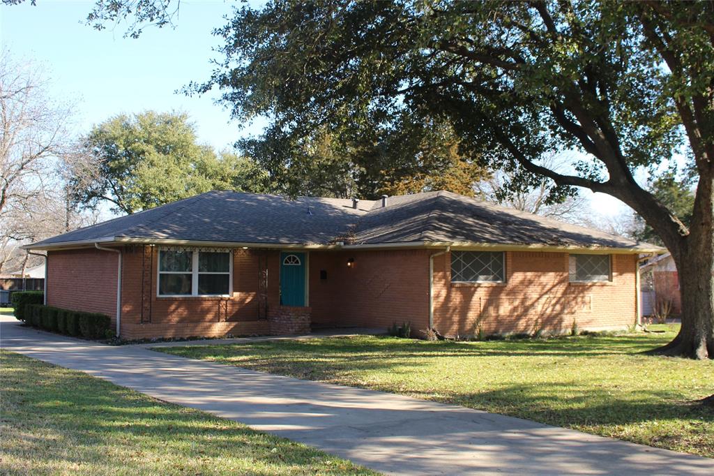 a front view of house with yard and trees around