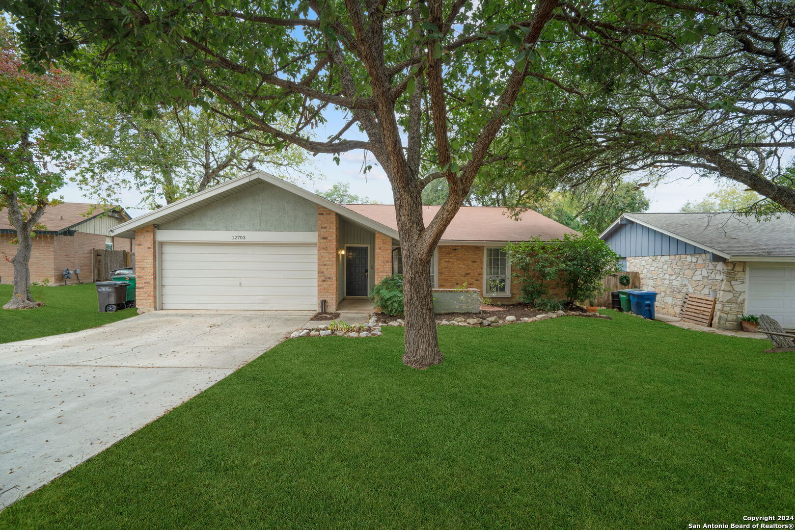 a front view of a house with yard and green space