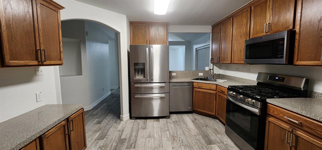 a kitchen with stainless steel appliances granite countertop a refrigerator stove and microwave