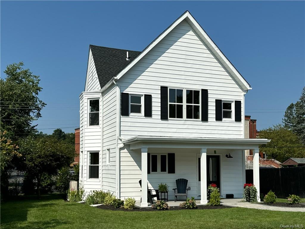 a view of a white house with yard and plants