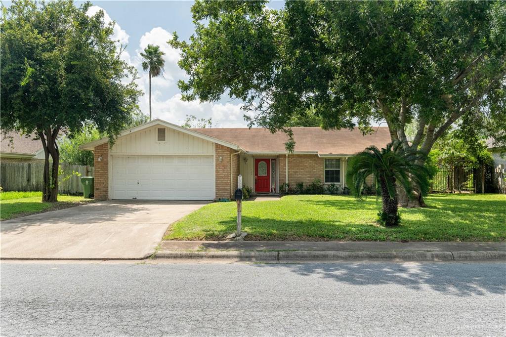 Single story home featuring a garage and a front lawn