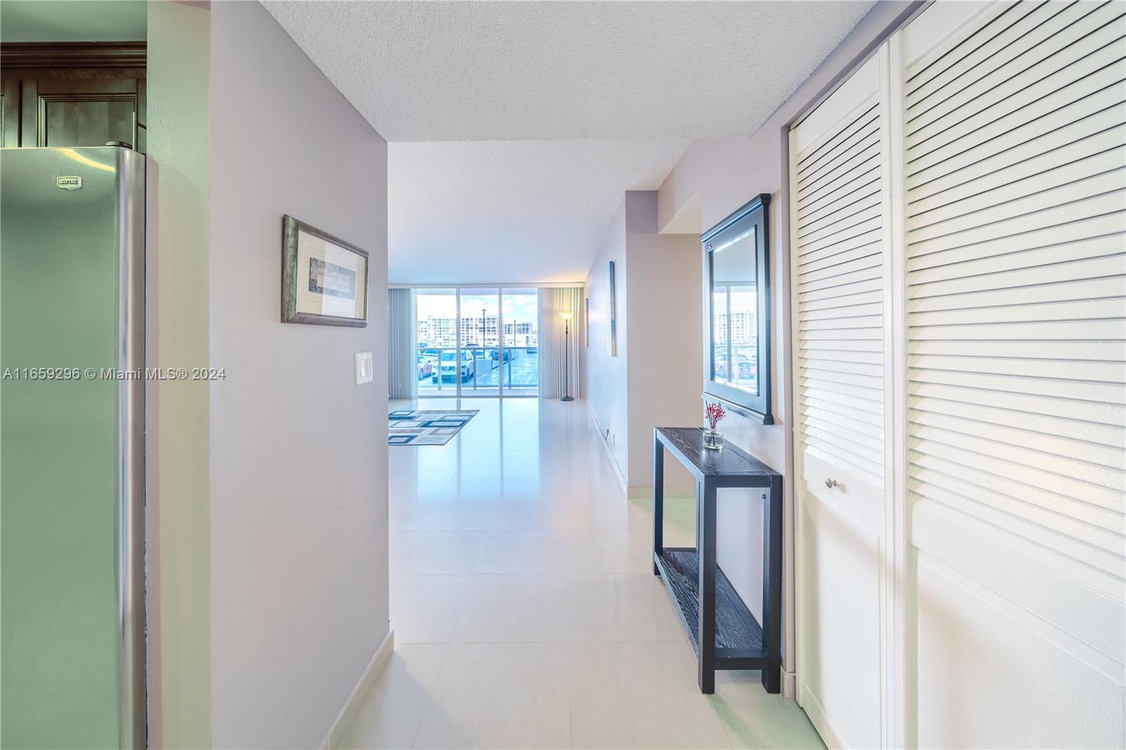 a view of hallway with furniture and floor to ceiling window