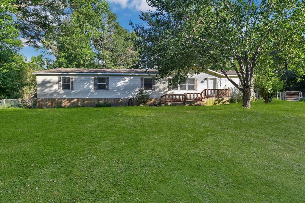 a view of a house with a big yard and large trees