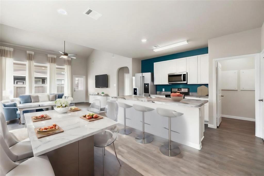 a kitchen that has a lot of cabinets a sink and appliances