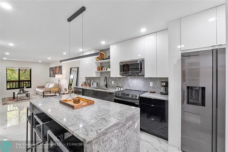 a kitchen with sink refrigerator and microwave