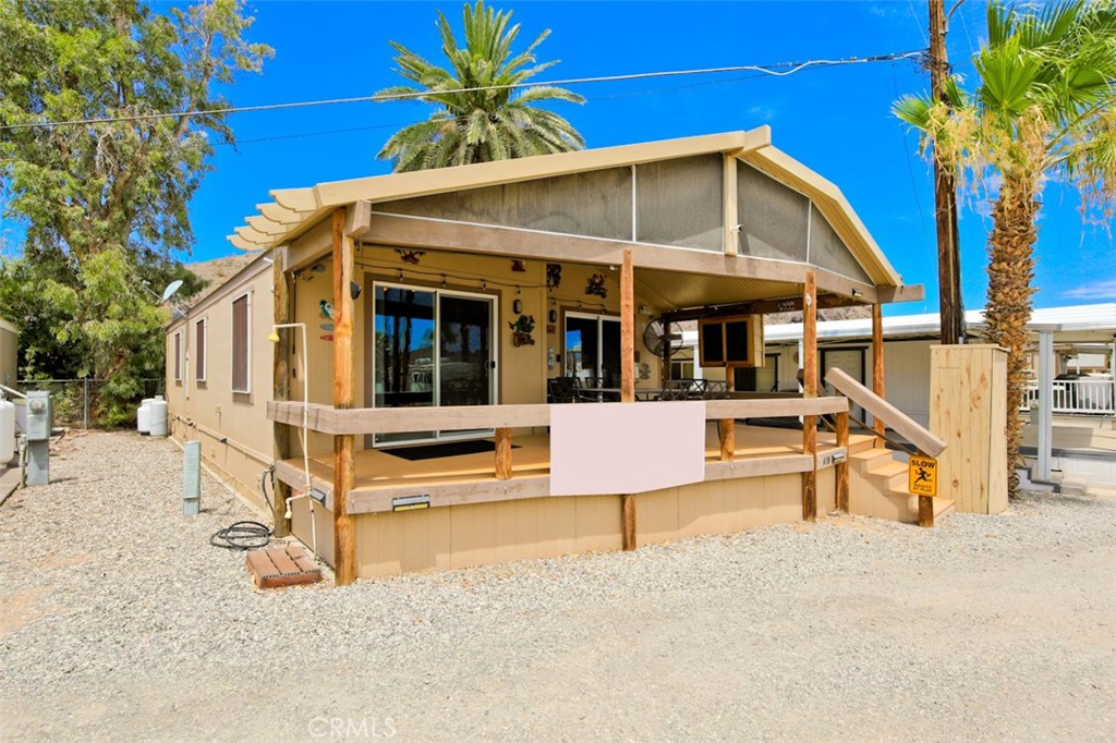 a view of house with a swimming pool and wooden bench