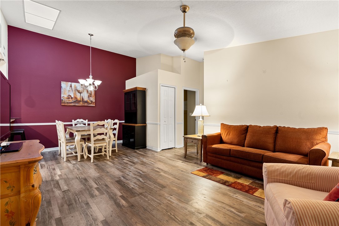 a living room with furniture a dining table and a chandelier