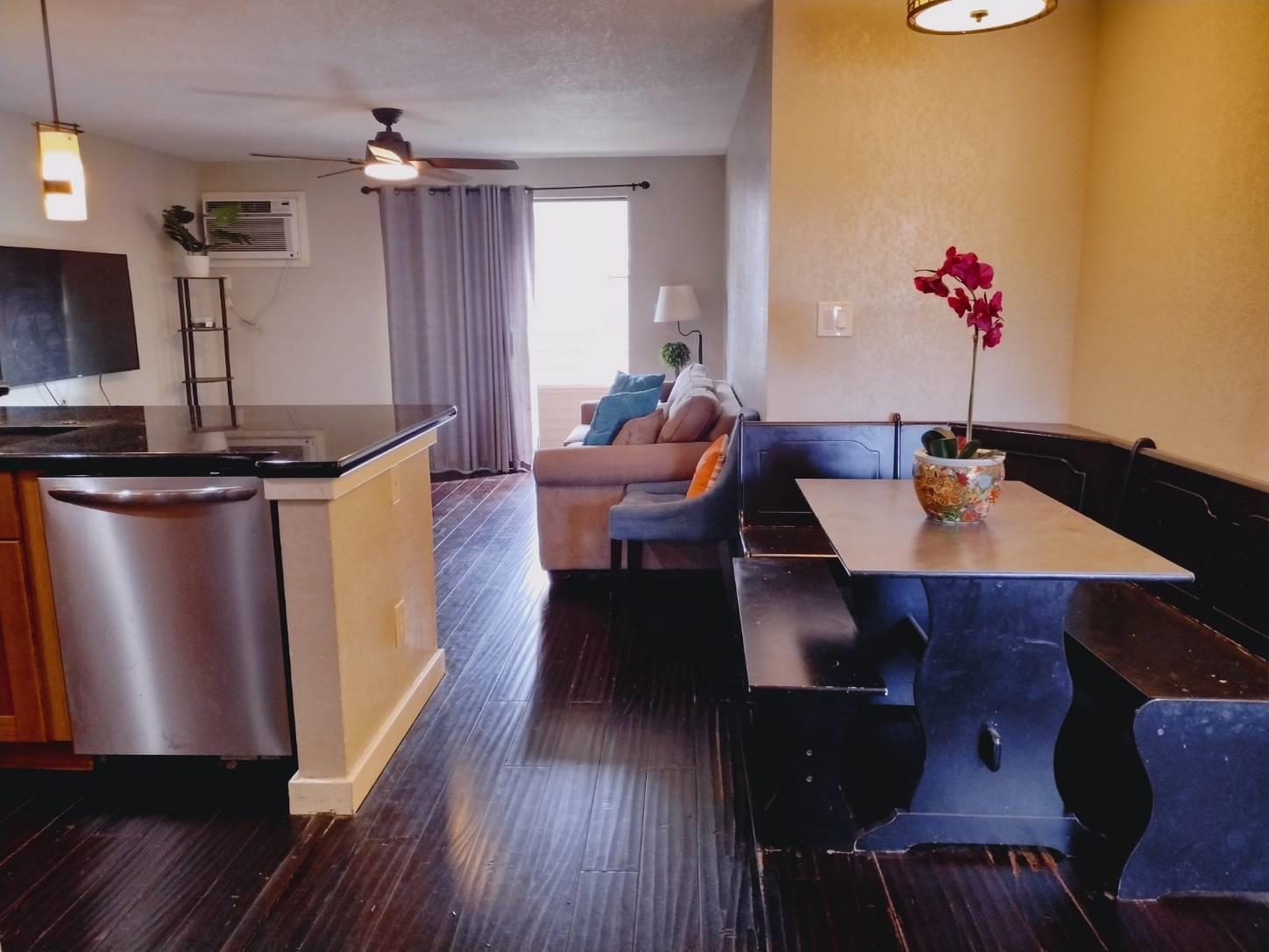 a living room with furniture a counter space and wooden floor