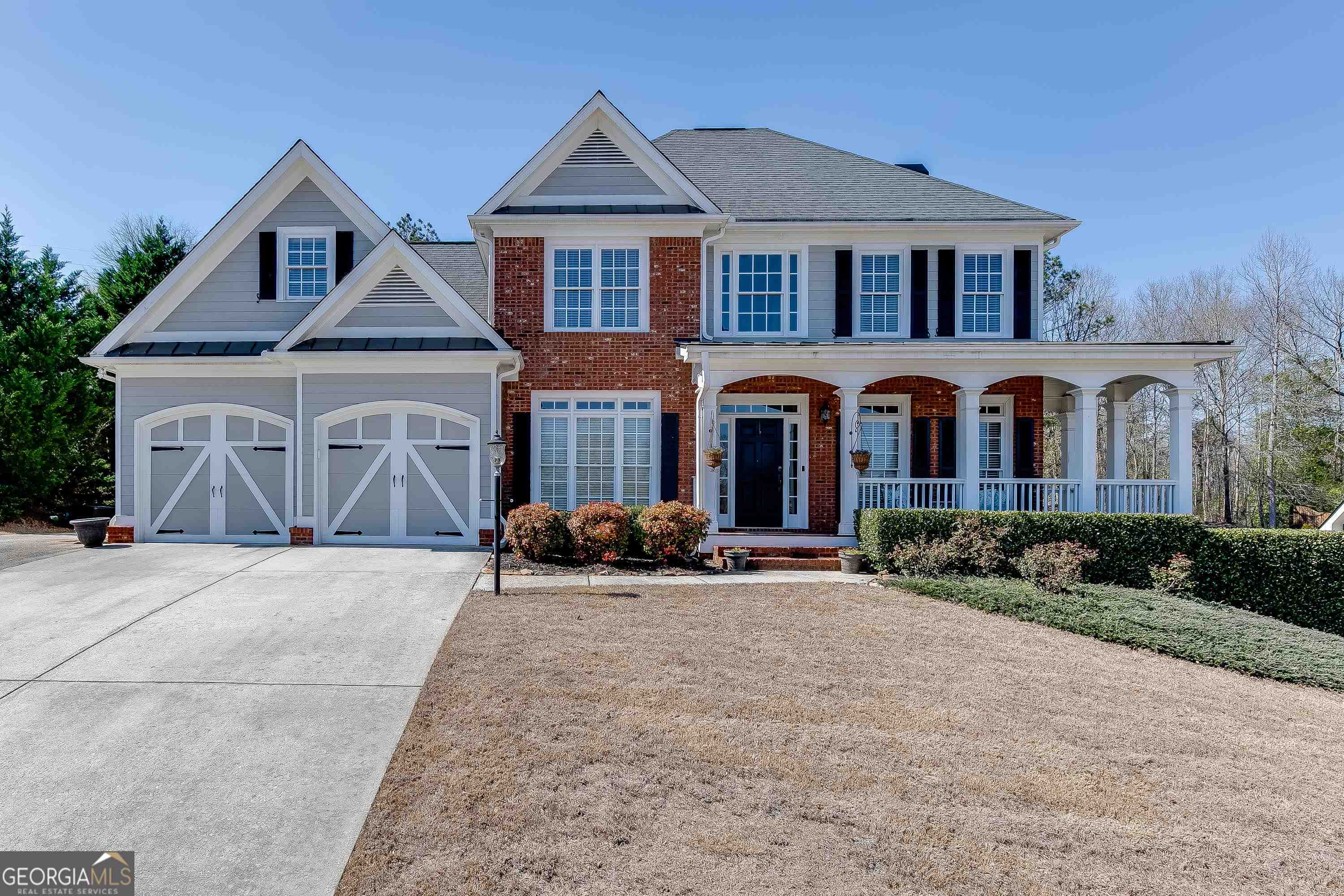 a front view of a house with yard and parking