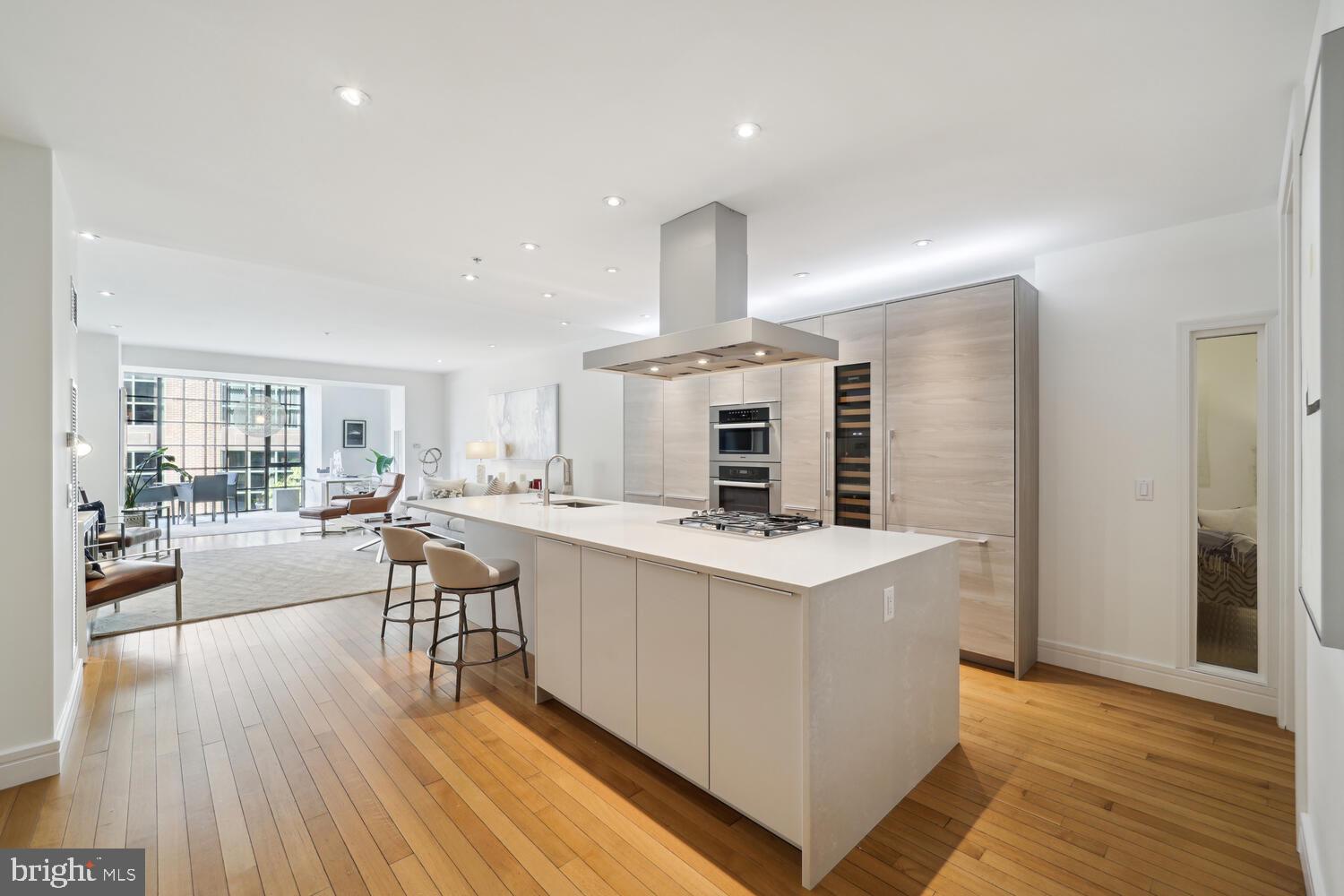 a kitchen with a stove a refrigerator and wooden floor