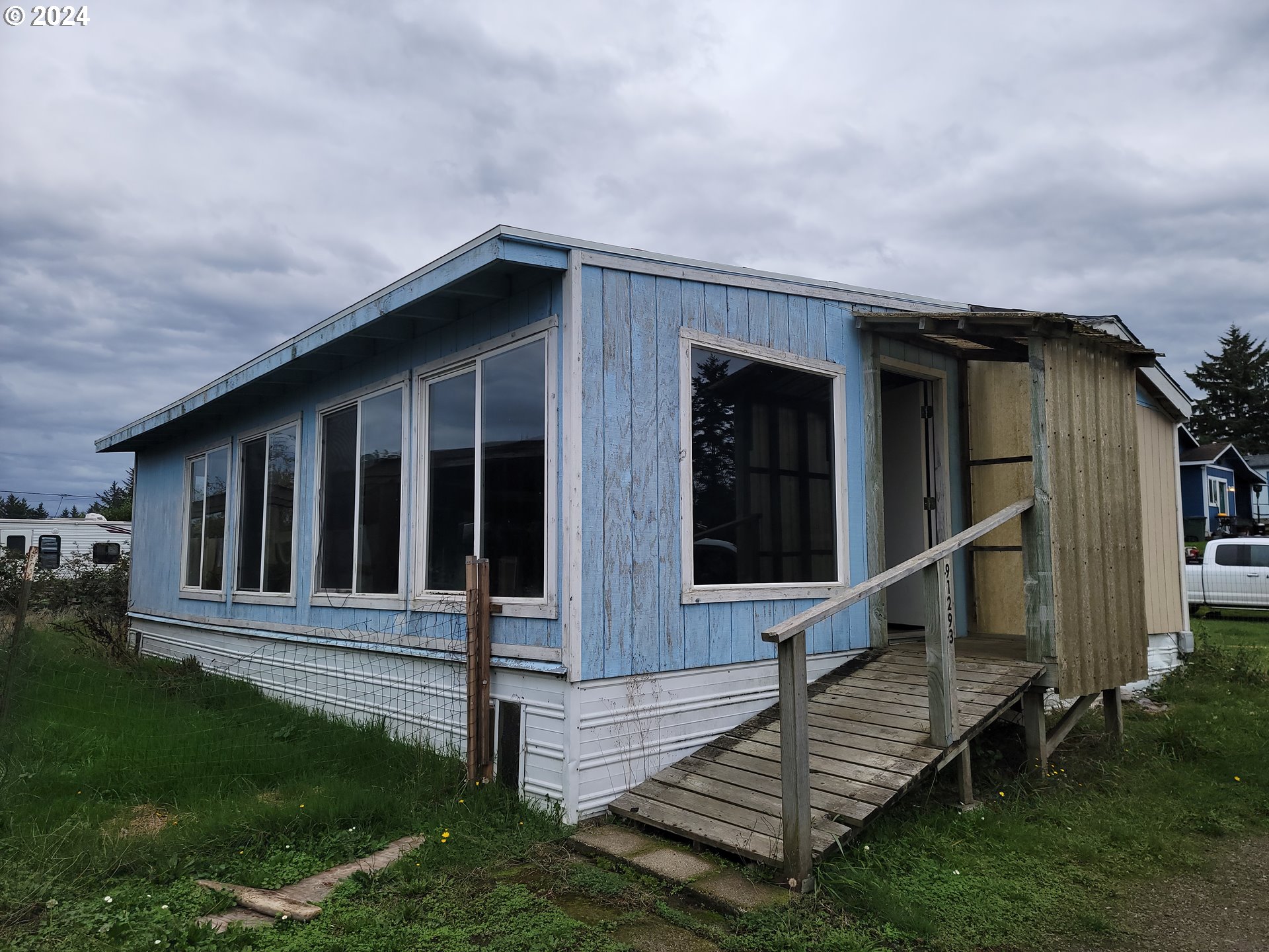 a view of wooden house with a yard