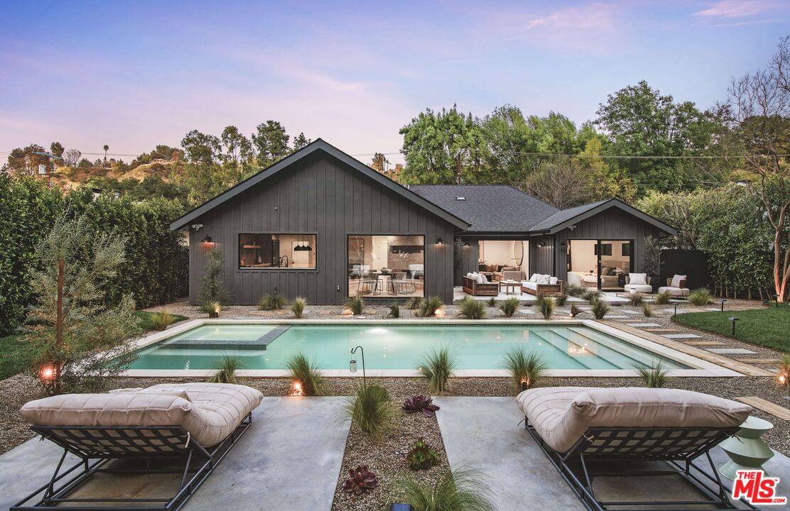 a view of a house with swimming pool and sitting area