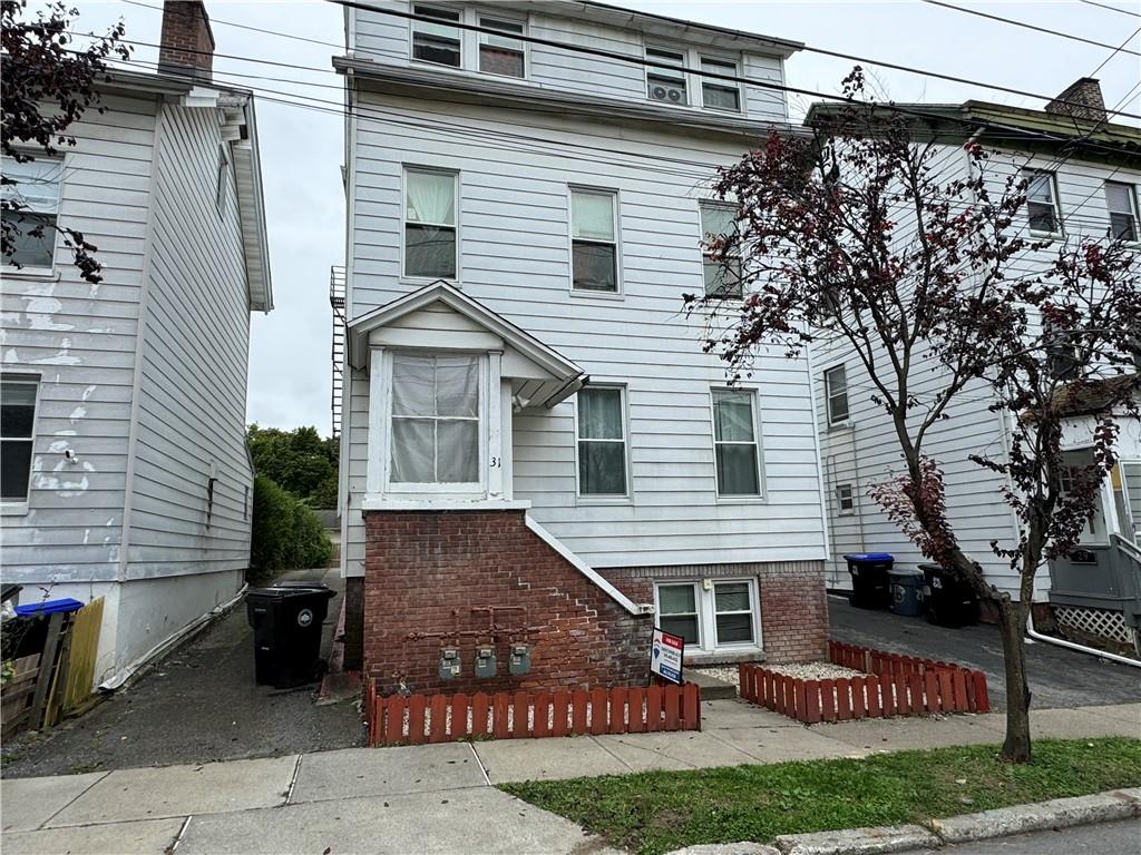 a view of a white house with large windows and a yard