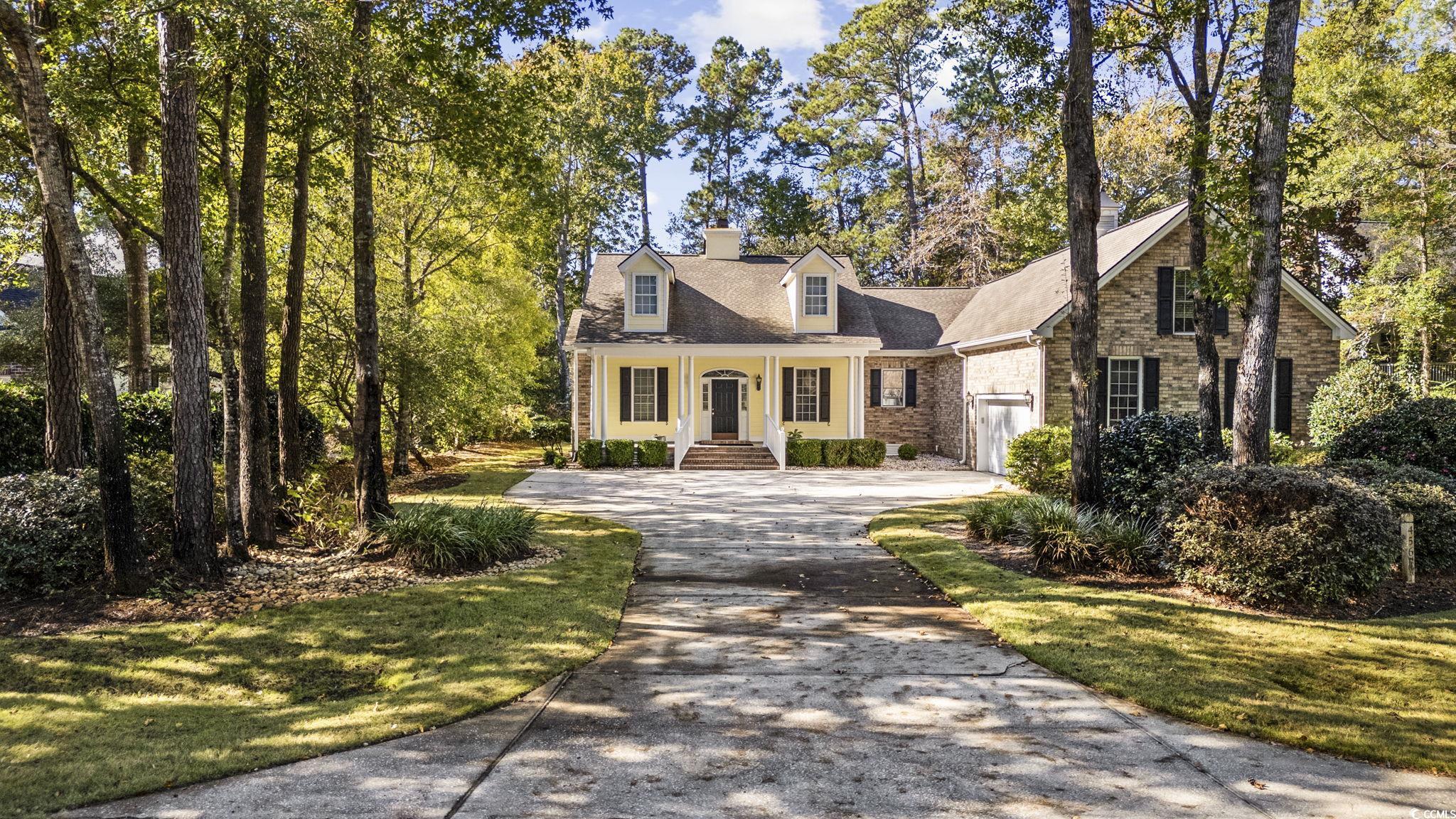 Cape cod house featuring a front yard and a porch