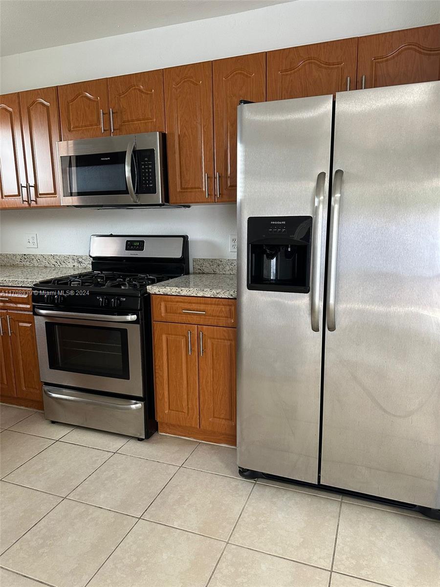 a kitchen with granite countertop a stove and a microwave