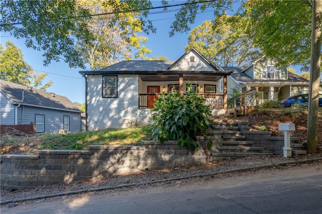 a front view of a house with a yard and potted plants