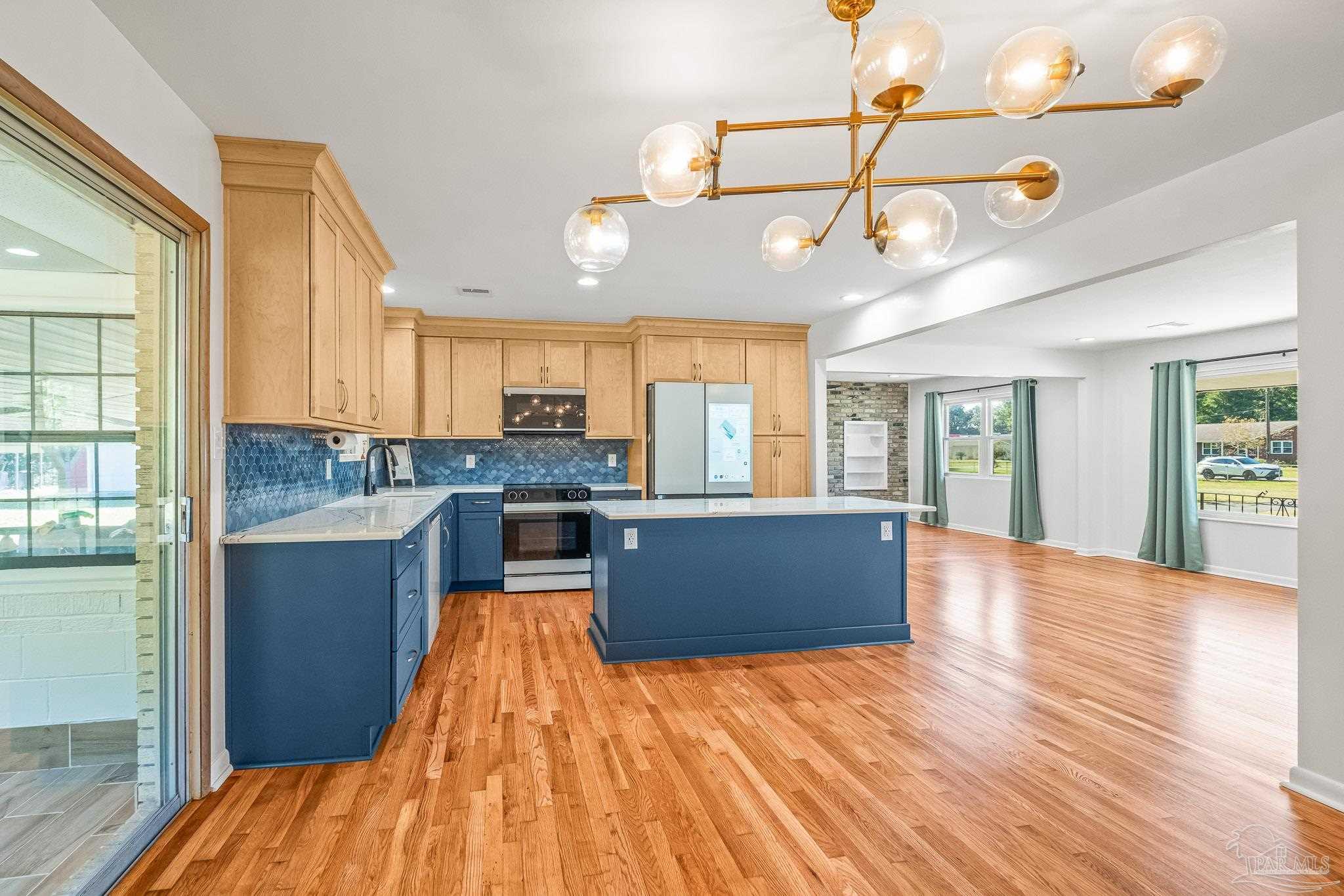 a large kitchen with cabinets wooden floor and stainless steel appliances