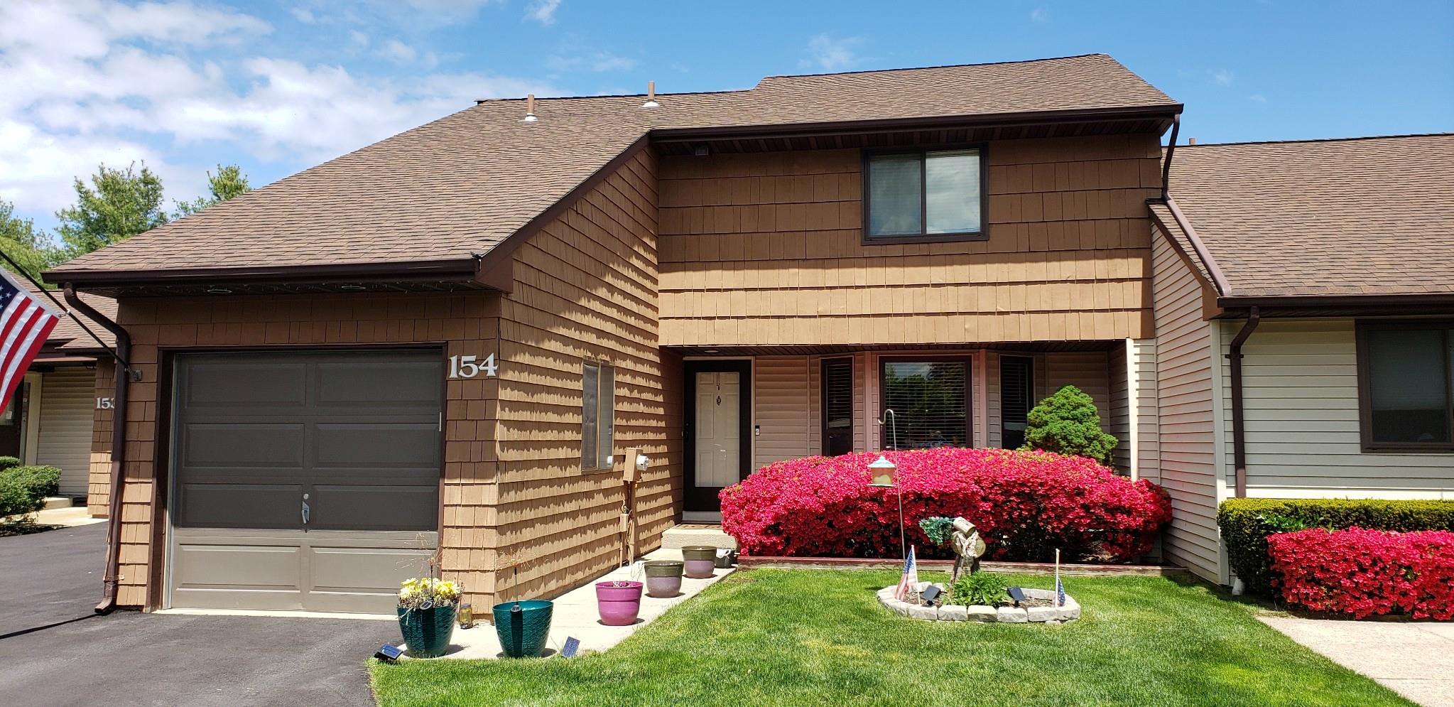 View of front of property featuring a front lawn and a garage