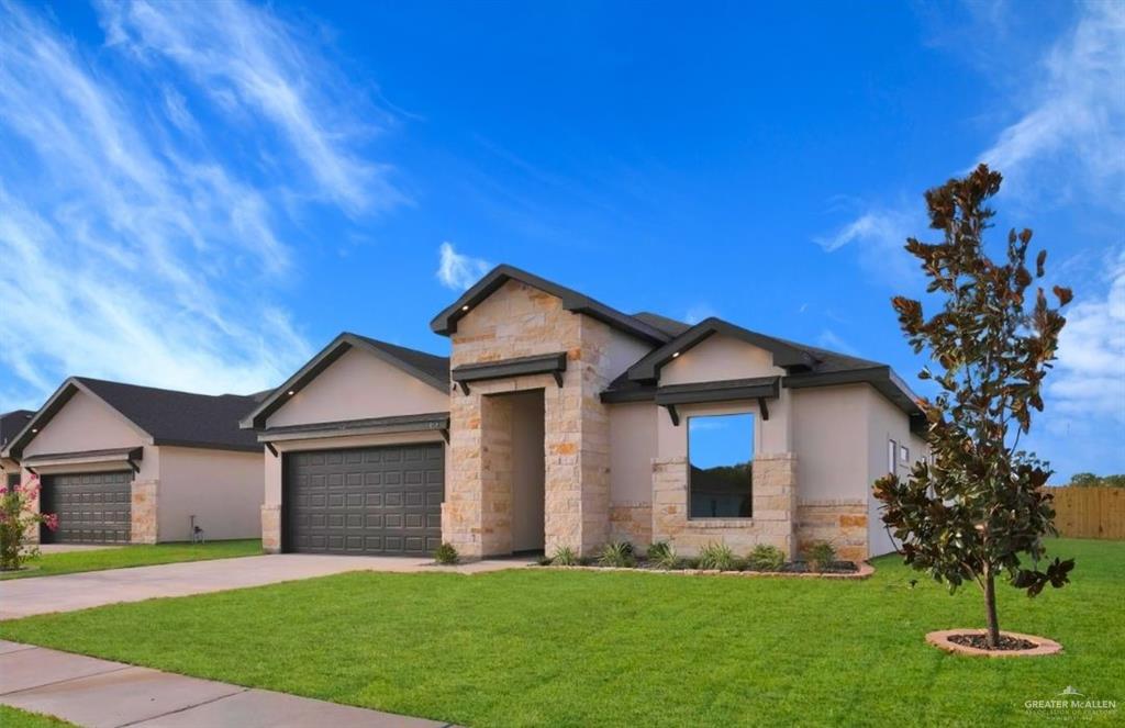 View of front of property featuring a front yard and a garage