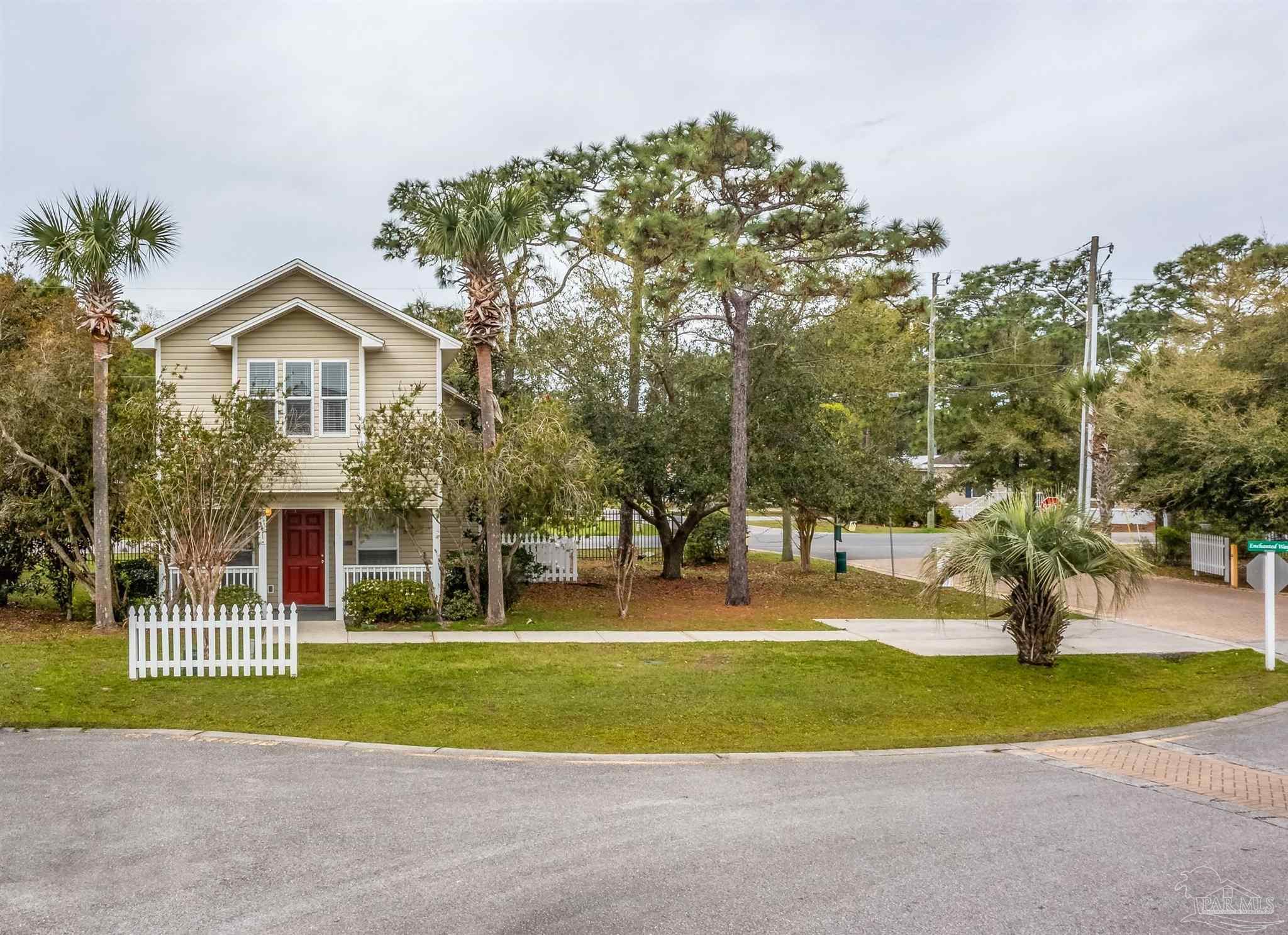 a view of a house with a yard and large trees