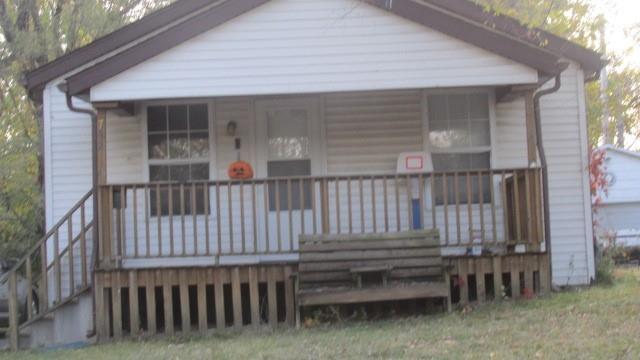 a view of a house with wooden deck and furniture