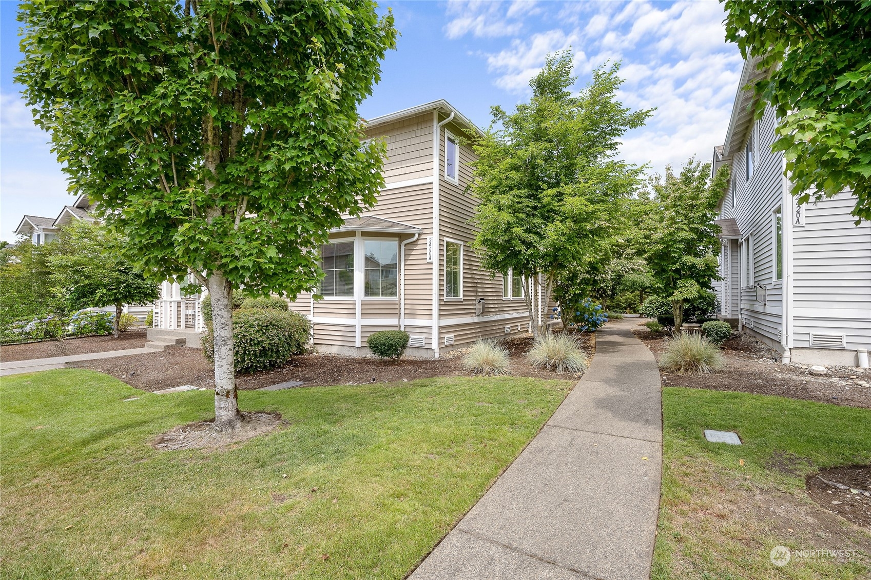 a front view of a house with a yard and trees