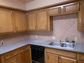 a kitchen with granite countertop stainless steel appliances white cabinets and a sink