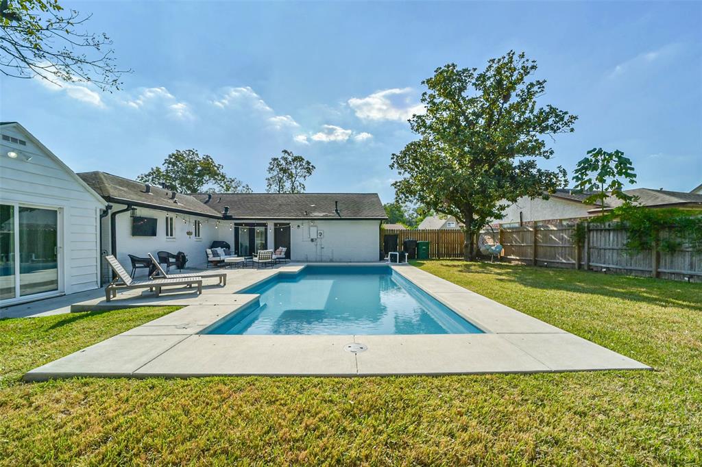 a view of a house with pool and a yard